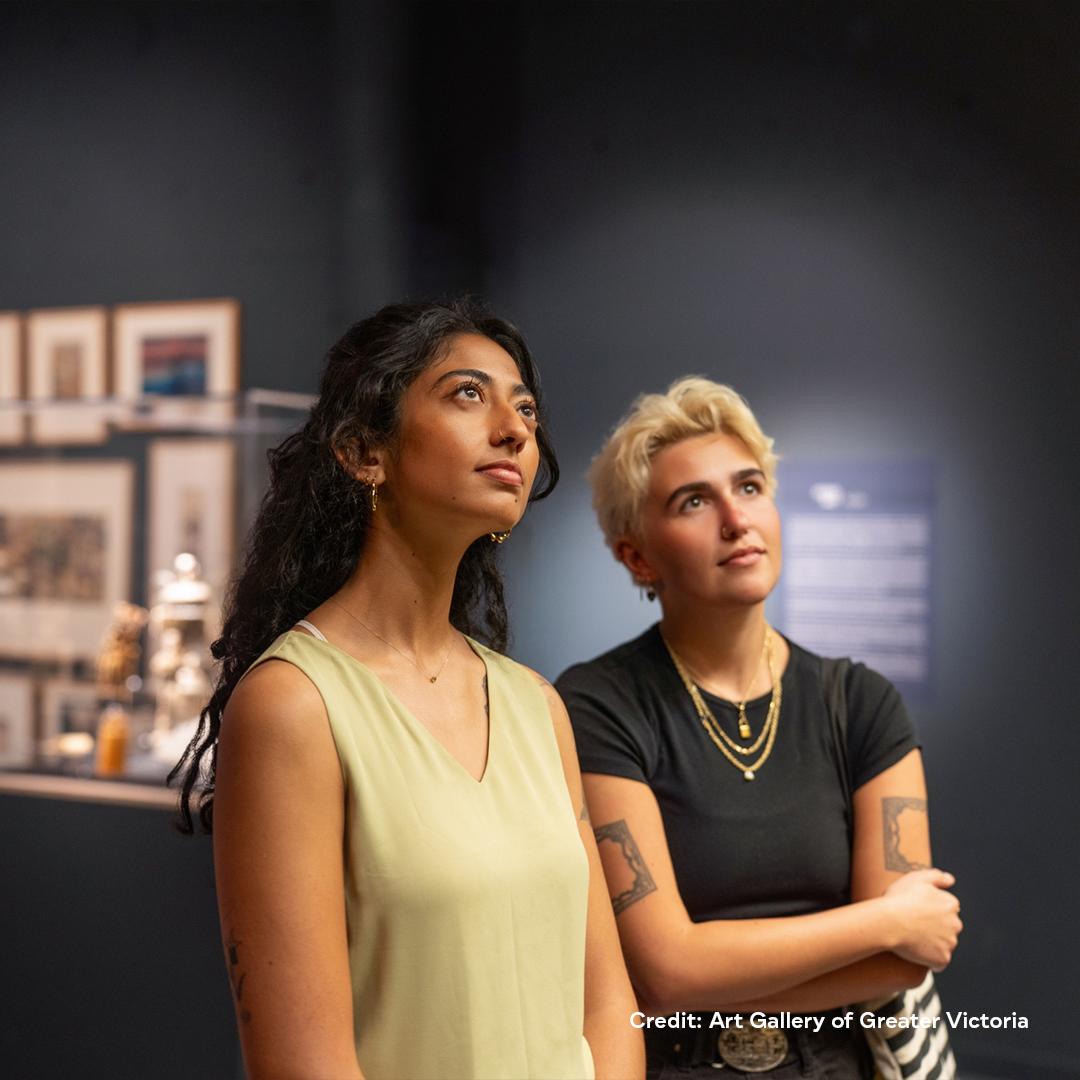 Two people examine the artwork inside the Art Gallery of Greater Victoria in Victoria, BC