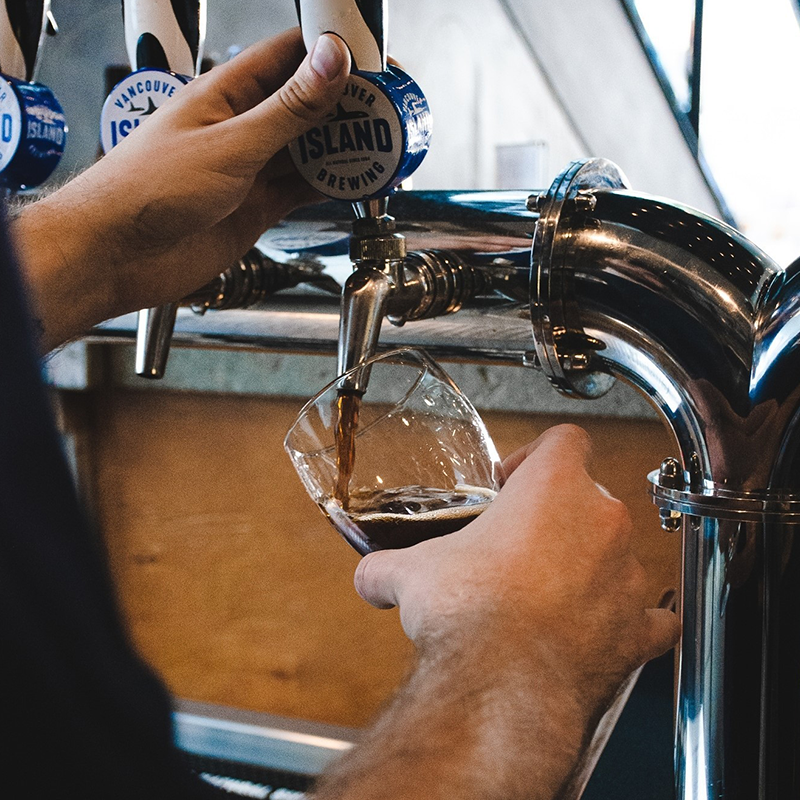 A bartender pouring a pint at the Vancouver Island Brewing tasting room